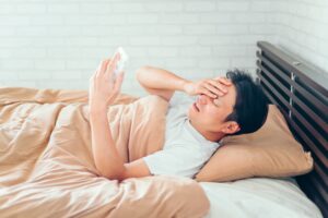 睡眠不足と生活リズムの乱れで朝からだるい男性