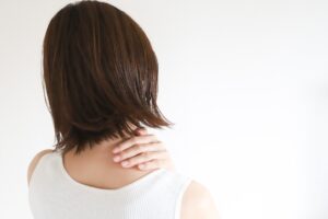 朝起きて首が回らない寝違えの症状に悩む女性